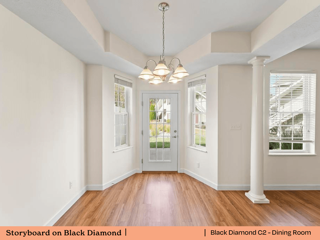 an empty living room with white walls and a door to a dining room
