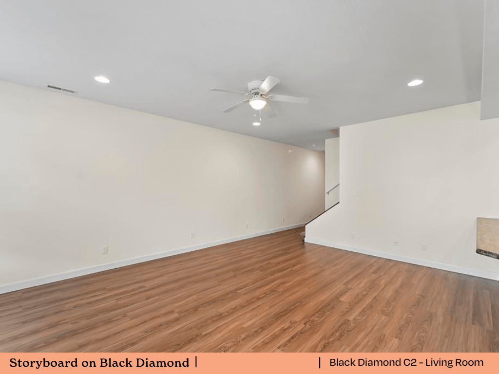 an empty living room with wood flooring and a ceiling fan