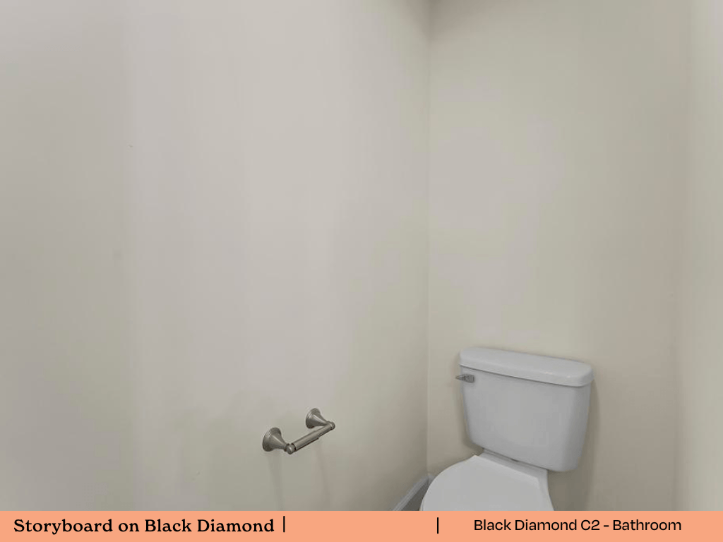 a bathroom with a toilet and a white wall