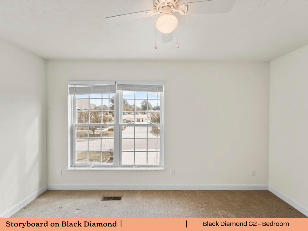 an empty room with a window and a ceiling fan