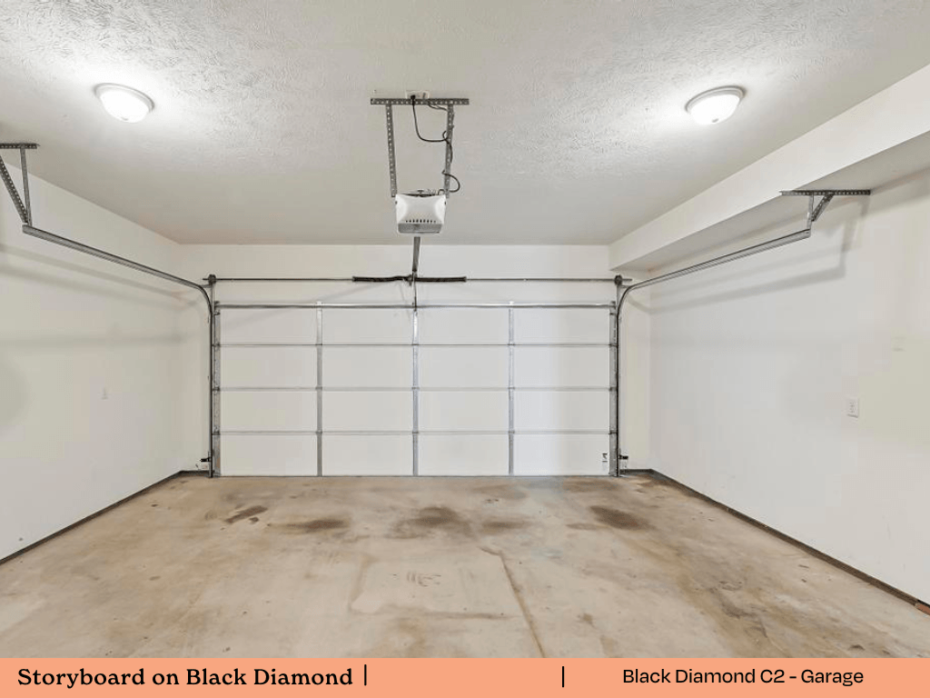 a empty garage with white walls and a wood floor