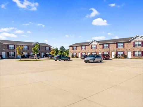 A parking lot with cars and apartment buildings in the background.