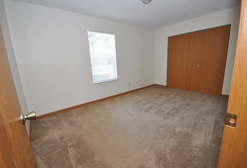 an empty room with a door and a window