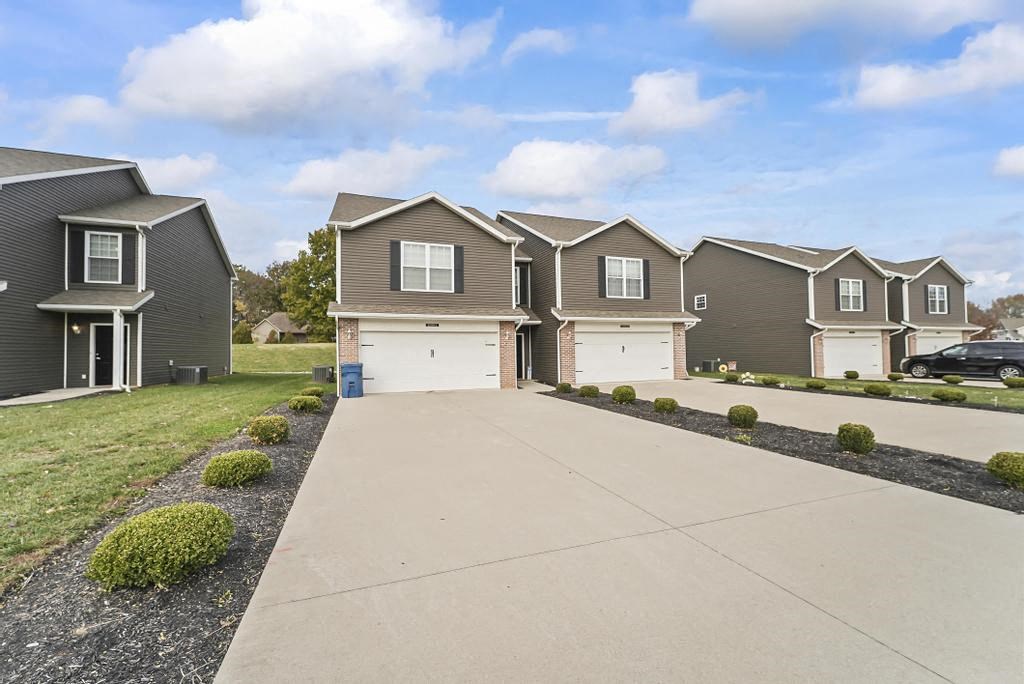 an empty driveway in front of a row of houses