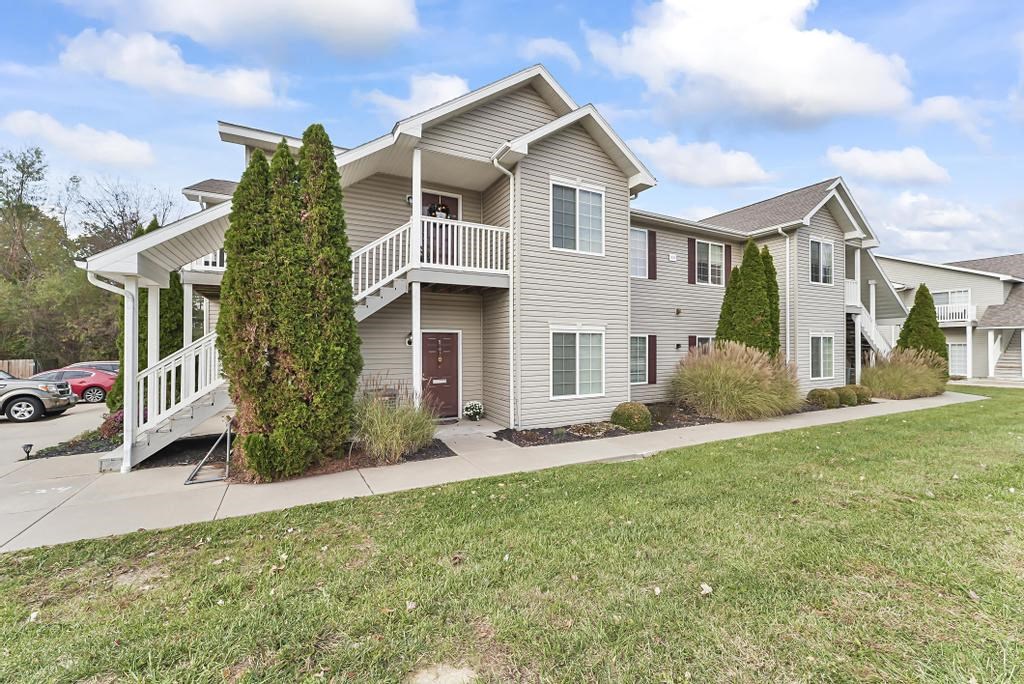 a gray house with a porch and a sidewalk