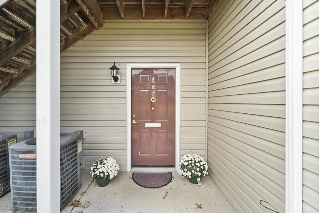 the front of a house with a red door and a porch
