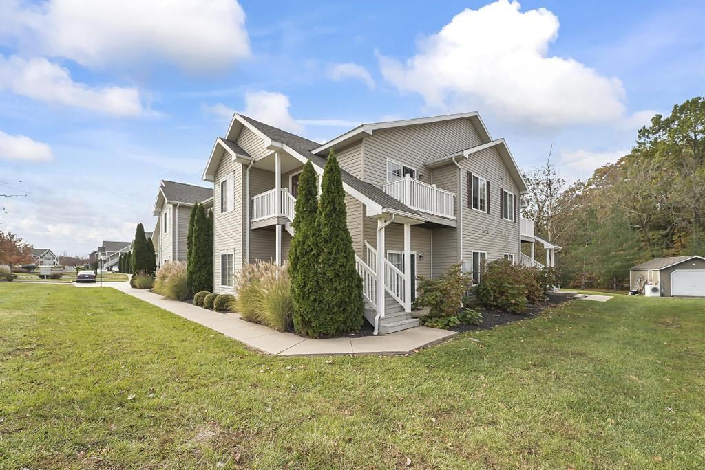 a gray house with a yard and a sidewalk