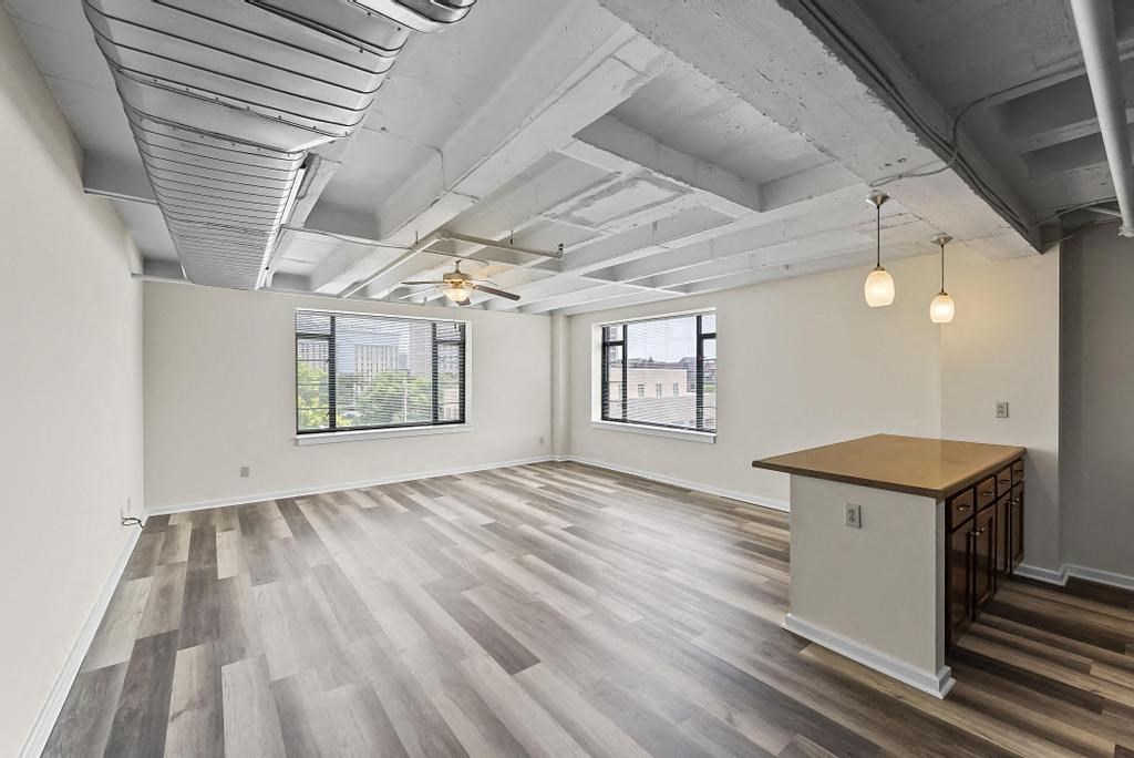 an empty room with a desk and two windows