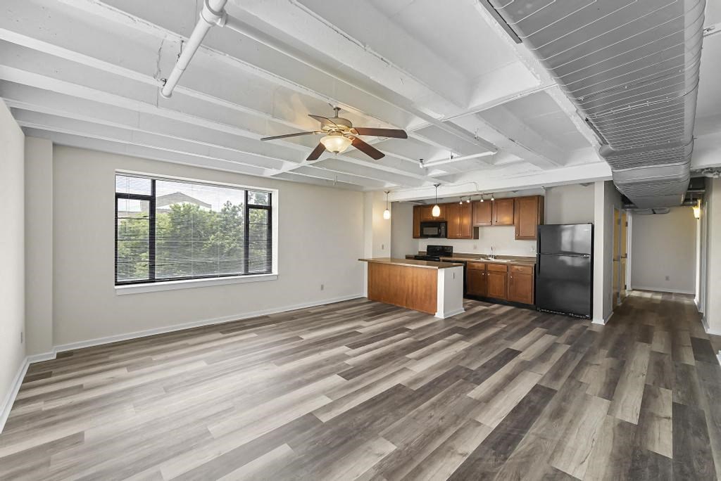 a kitchen and living room with a ceiling fan