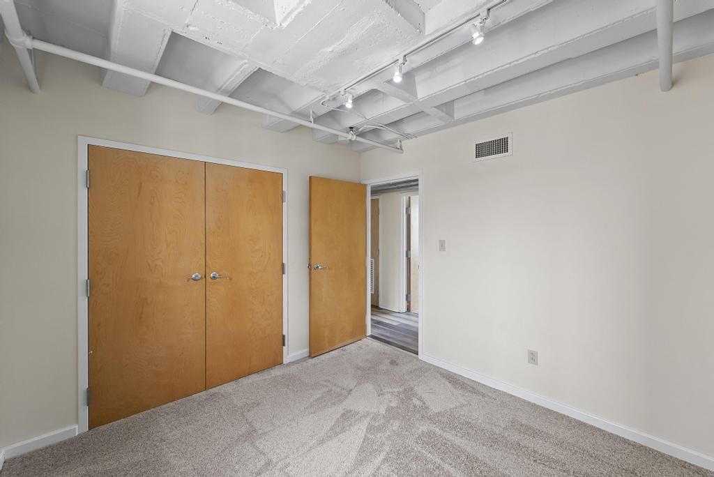 a bedroom with two doors and a carpeted floor