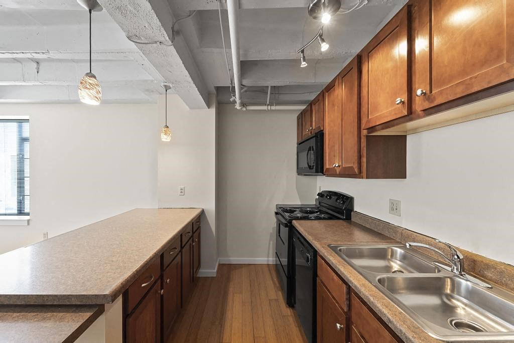 a kitchen with wooden cabinets and a black stove top oven