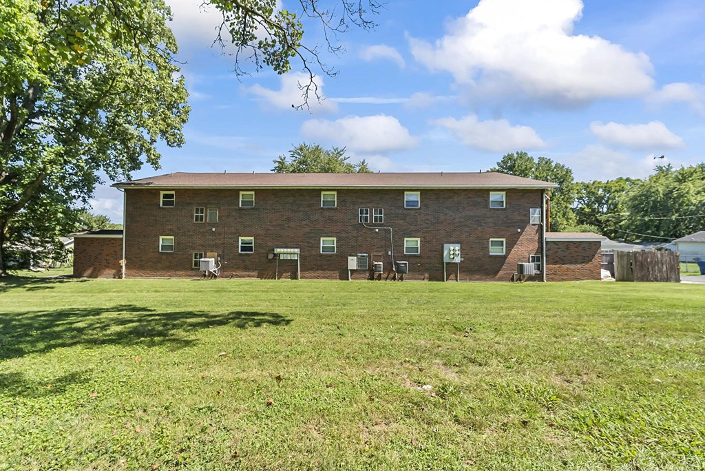a large brick building with a grassy area in front of it