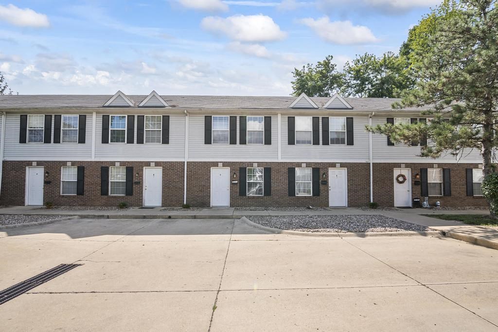 a brick apartment building with white doors and windows