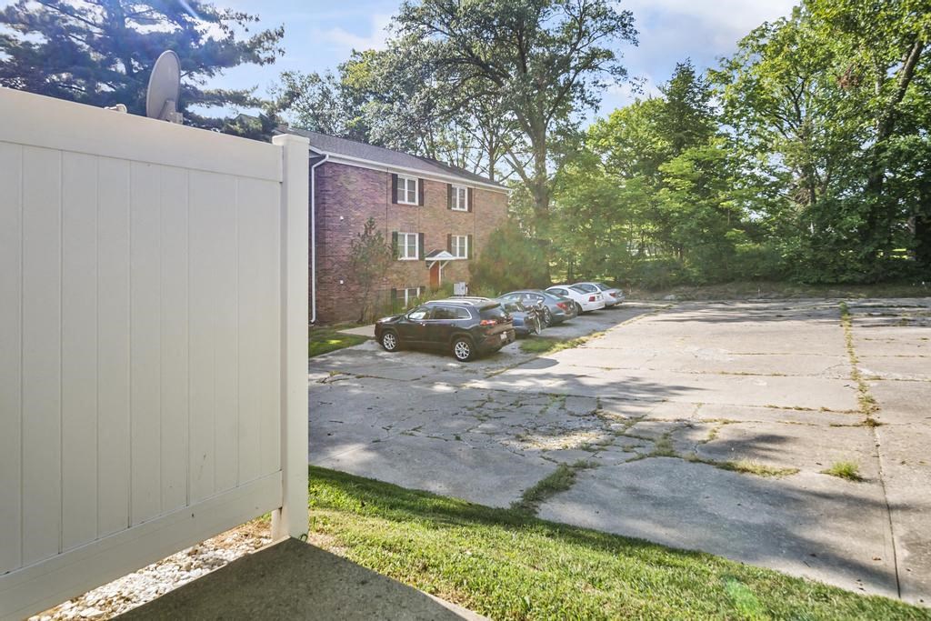a white fence in front of a parking lot