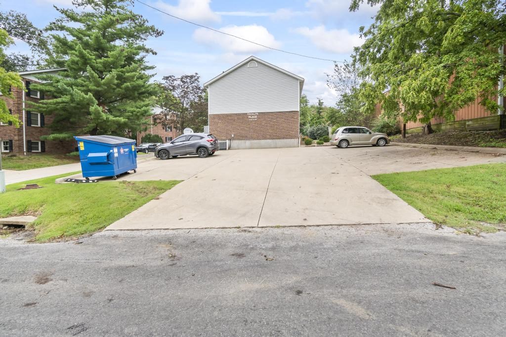 a blue dumpster sits on the side of a driveway