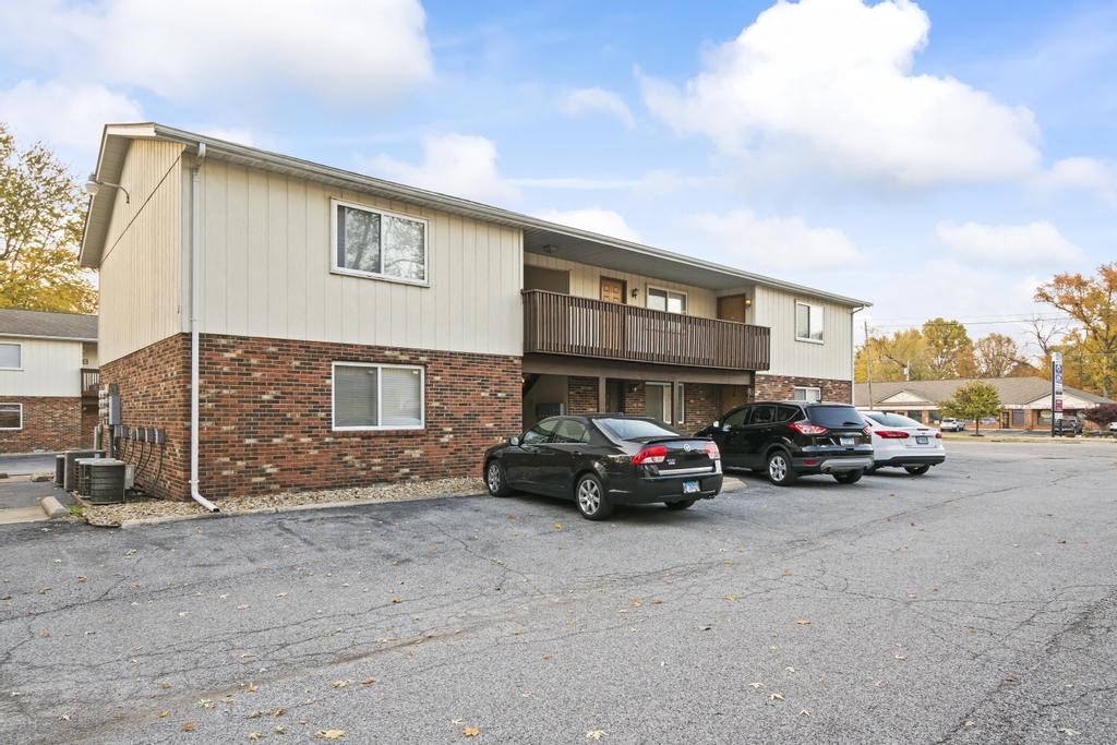 an apartment building with cars parked in a parking lot