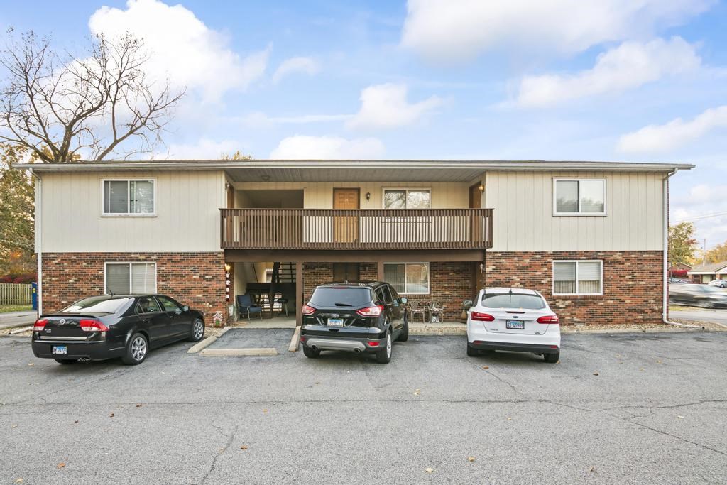 an apartment building with cars parked in a parking lot