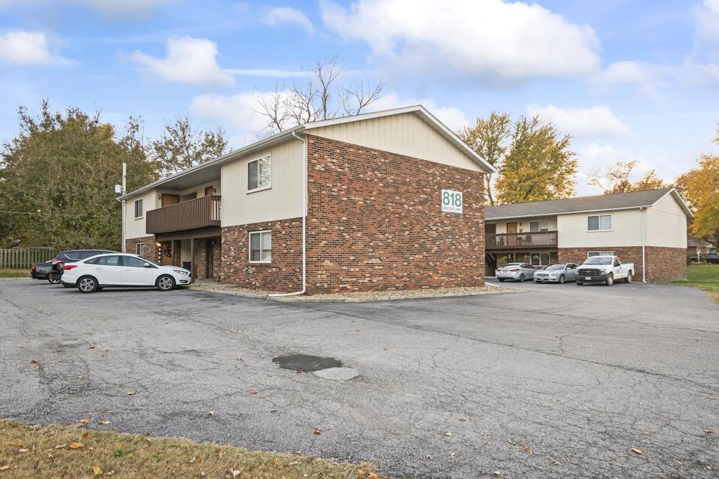a parking lot in front of a brick apartment building