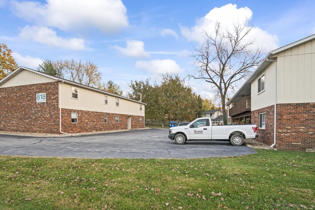 a white truck parked in a driveway next to a brick building