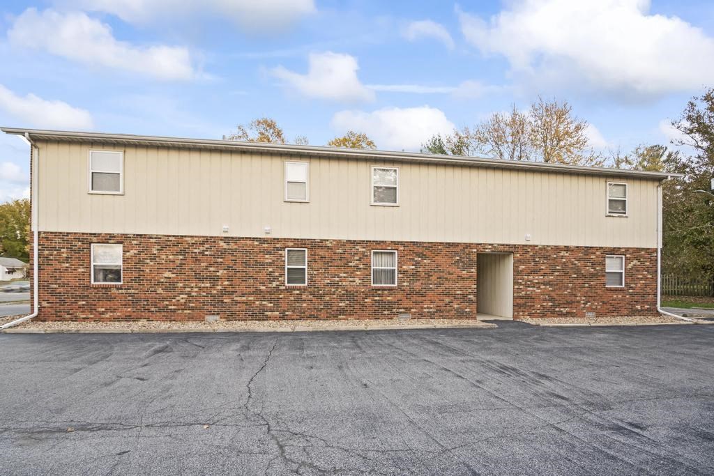 the front of a brick building with a garage door