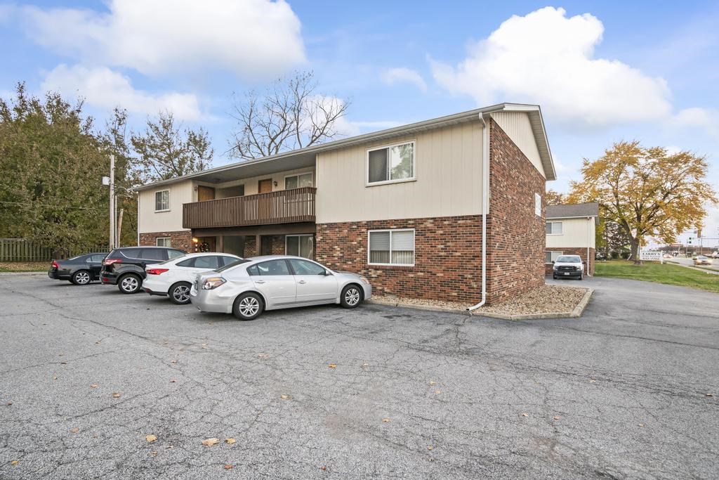 an apartment building with cars parked in front of it