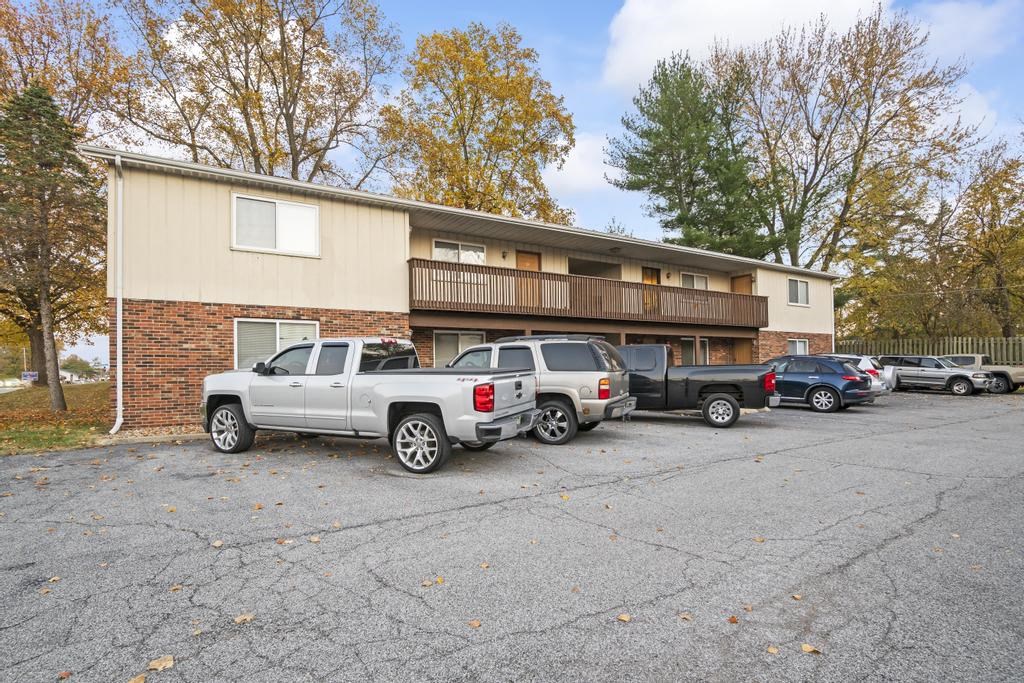 a parking lot with trucks parked in front of a building