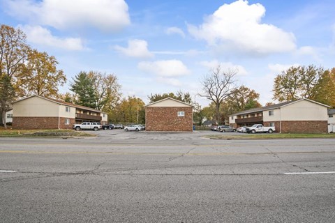an empty street in a neighborhood with houses and cars