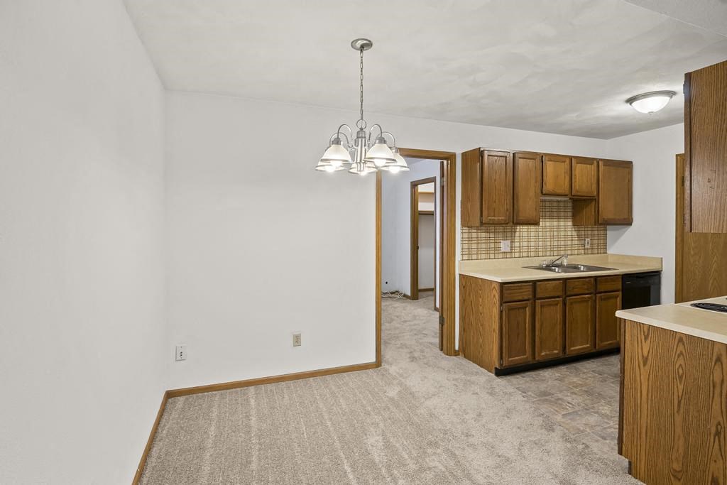 an empty kitchen with wooden cabinets and a sink