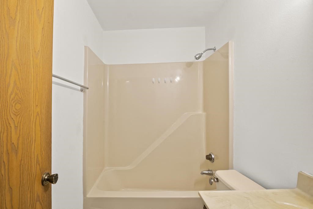 a bathroom with a shower and a sink and a toilet