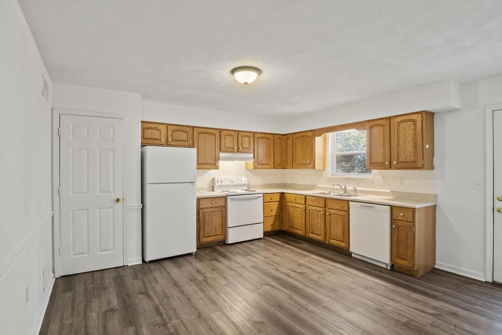 a kitchen with white appliances and wooden cabinets
