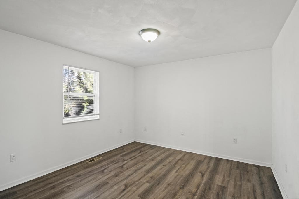 an empty living room with white walls and a window