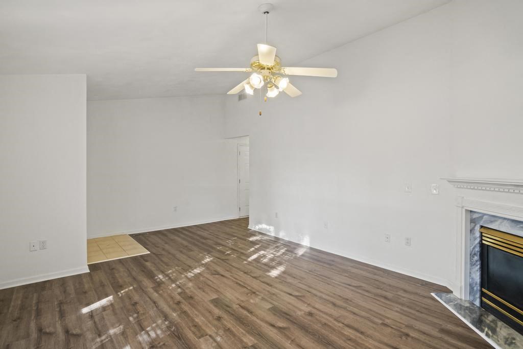 a living room with a fireplace and a ceiling fan