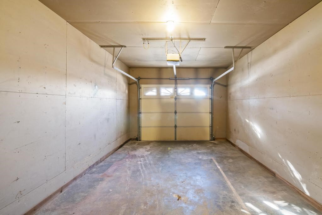 the inside of a room with white walls and a garage door
