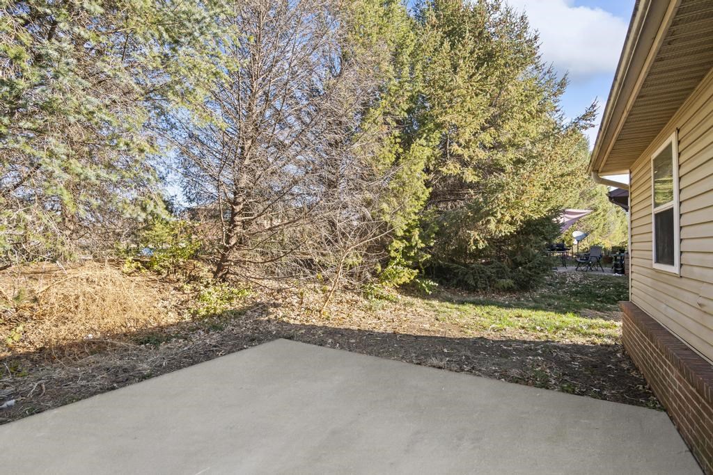 a covered patio with trees in the background on a sunny day