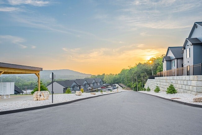 A residential street with houses on both sides and a clear sky.
