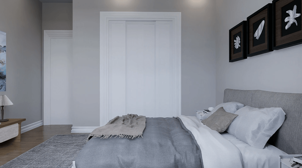A bedroom with a bed, pillows, and pictures on the wall.