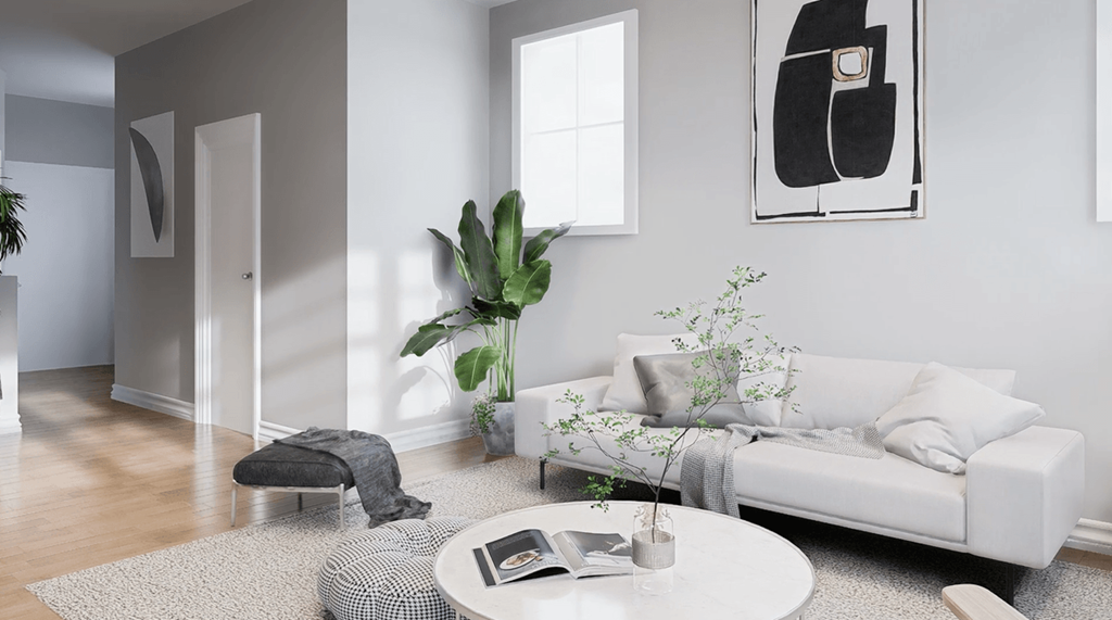 A living room with a white couch, a coffee table, and a potted plant.