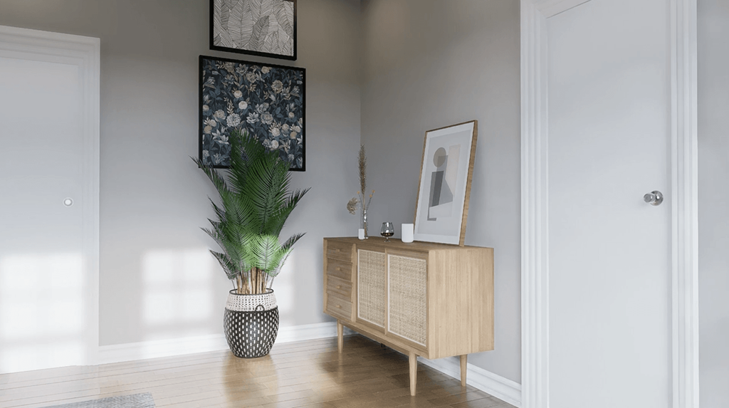 A room with a wooden cabinet, a potted plant, and a framed picture on the wall.