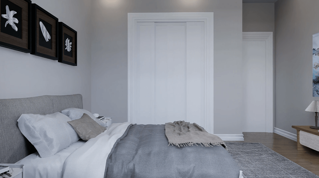 A bedroom with a bed, pillows, a blanket, a nightstand, and pictures on the wall.