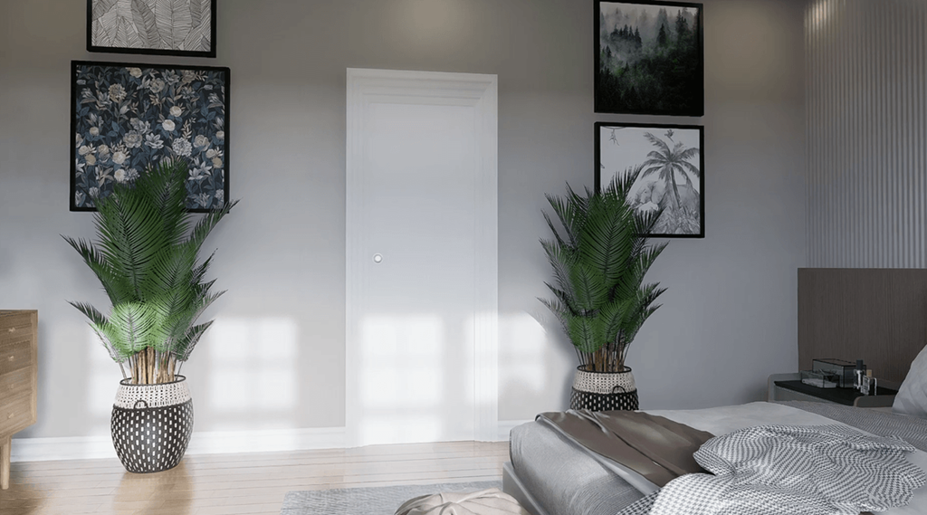 A bedroom with a bed, a potted plant, and pictures on the wall.