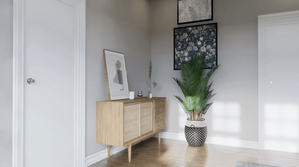 A wooden cabinet with a framed picture of a man and a potted plant on a wooden floor.
