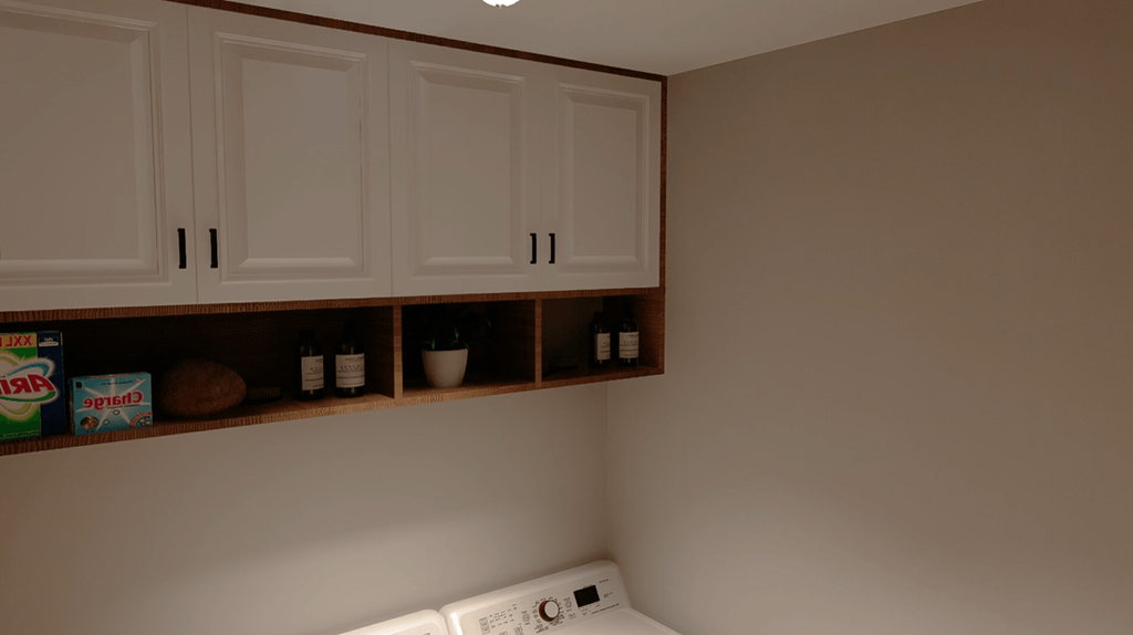 A kitchen with white cabinets and a white fridge.