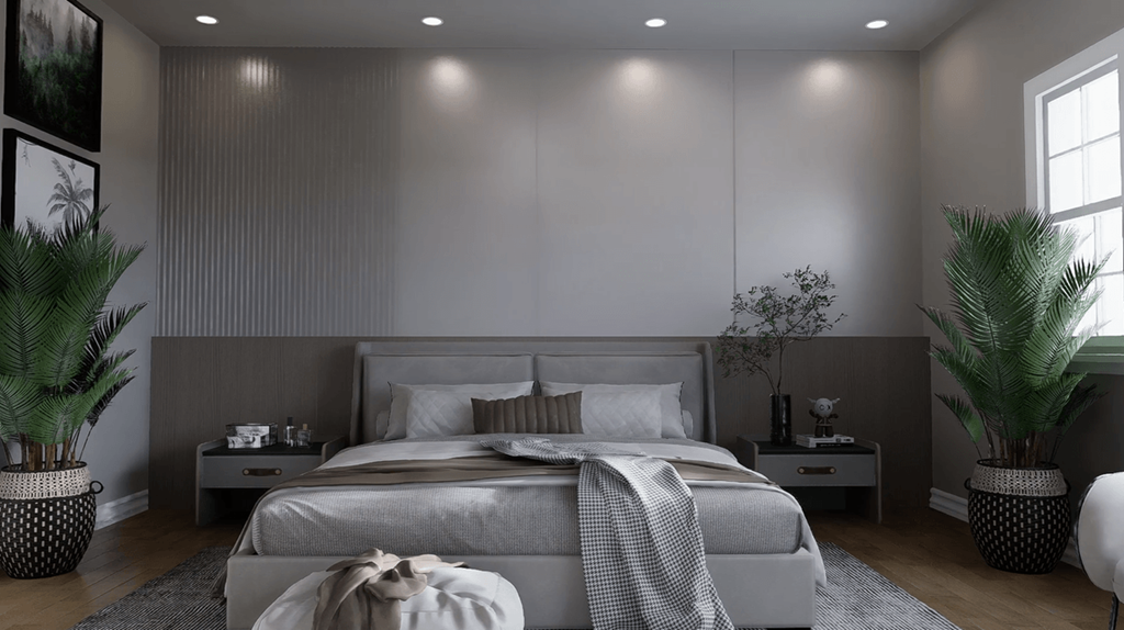 A bedroom with a large bed and two potted plants.