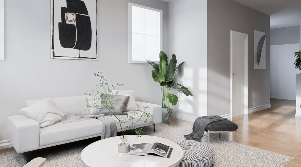 A living room with a white sofa, a coffee table, and a potted plant.