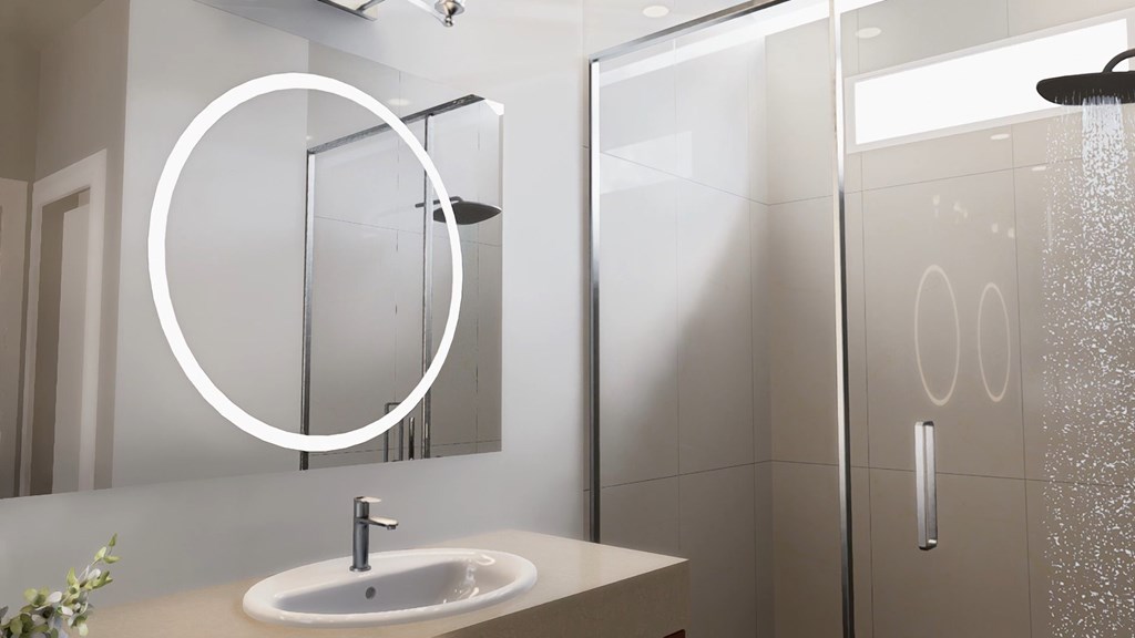 A modern bathroom with a white sink and a shower with a glass door.