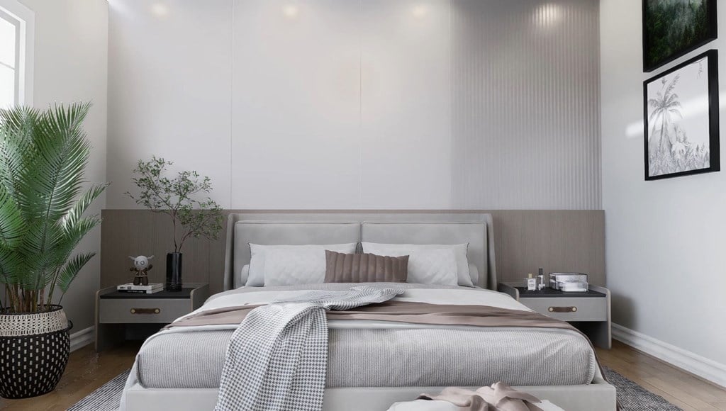 A bedroom with a large bed and a potted plant.