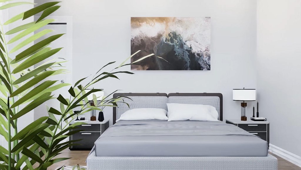 A bedroom with a large bed and a painting on the wall.