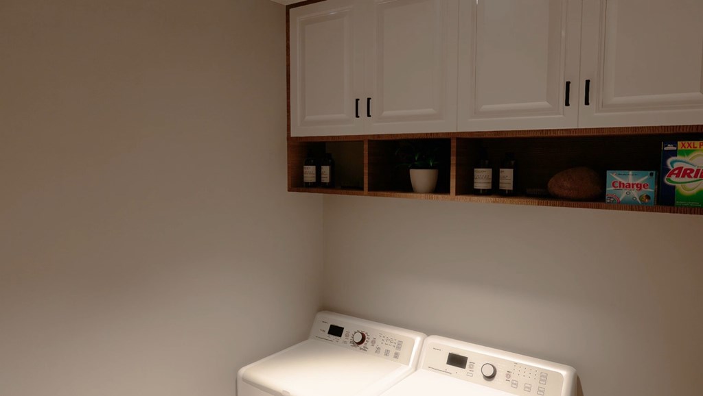 A white washing machine sits in a laundry room.