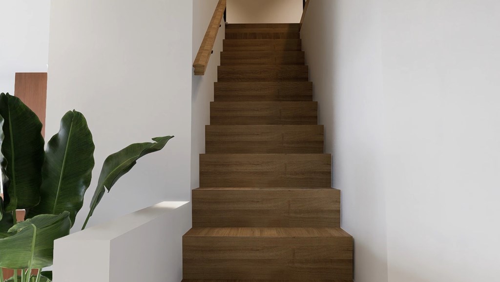 A staircase with wooden steps and a white wall.