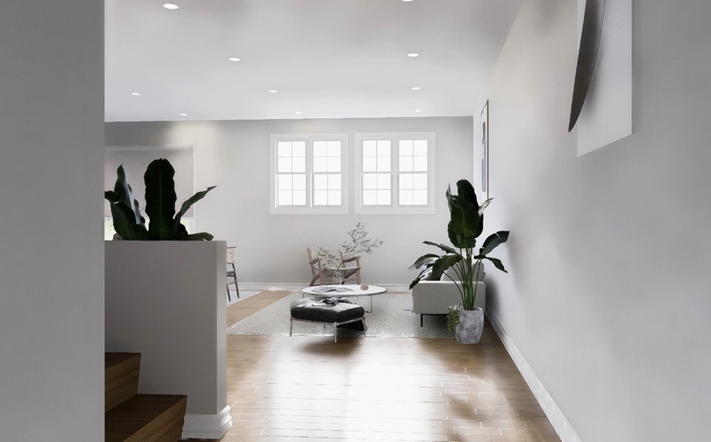A living room with a white couch and a large window.